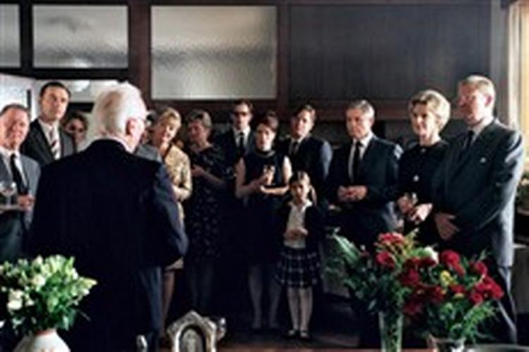 Hele  Familien Bella  er samlet for at hylde Kaj Holger på hans 60-års fødselsdag. Sønnen Eriks symbolske placering i baggrunden indikerer ikke alene hans tabte kamp mod faderen, men også hans videre skæbne i  Kr&amp;amp;osla 