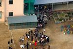 Elever bliver gelejdet ud i skolegården efter knivoverfaldet på skolen i byen Neyagawa nær Osaka. - Foto: AP 
