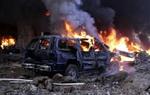 Mindst 20 biler står i flammer efter eksplosionen, og facaderne på flere bygninger i nærheden er kraftigt beskadiget. - Foto: AP 