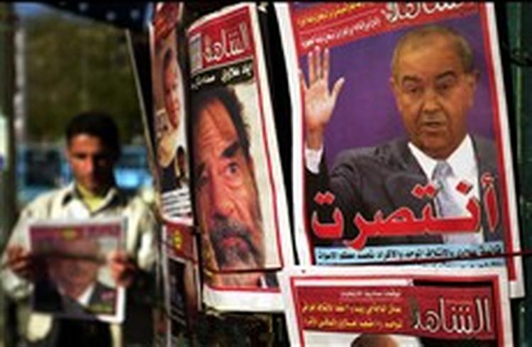 Pressen i Bagdad skriver intenst om regeringsforhandlingerne. Ministerpræsident Allawi på en af forsiderne er på vej ud   og Saddam i baggrunden er historie.   Foto: Mohammed Uraibi /AP 