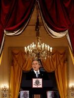 Bush taler til de få hundrede særligt indbudte, mens tusindvis af demonstranter fylder Bruxelles gader. - Foto: AP 