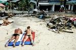 Martin Lehmanns vinderbillede af et dansk par, der soler sig på stranden i Puhket, Thailand, mens oprydningsarbejdet efter flodbølgen foregår omkring dem. - Foto: Martin Lehmann 