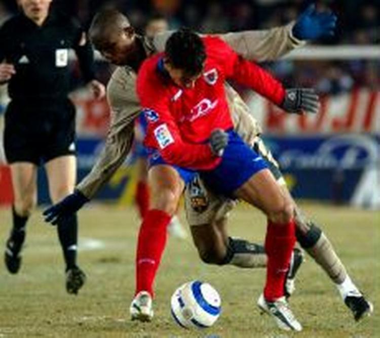 Samuel Eto'o i en nærkamp med en Numancia-forsvarer. Eto'o havde en skidt aften på den frosthårde bane. - Foto: AP 