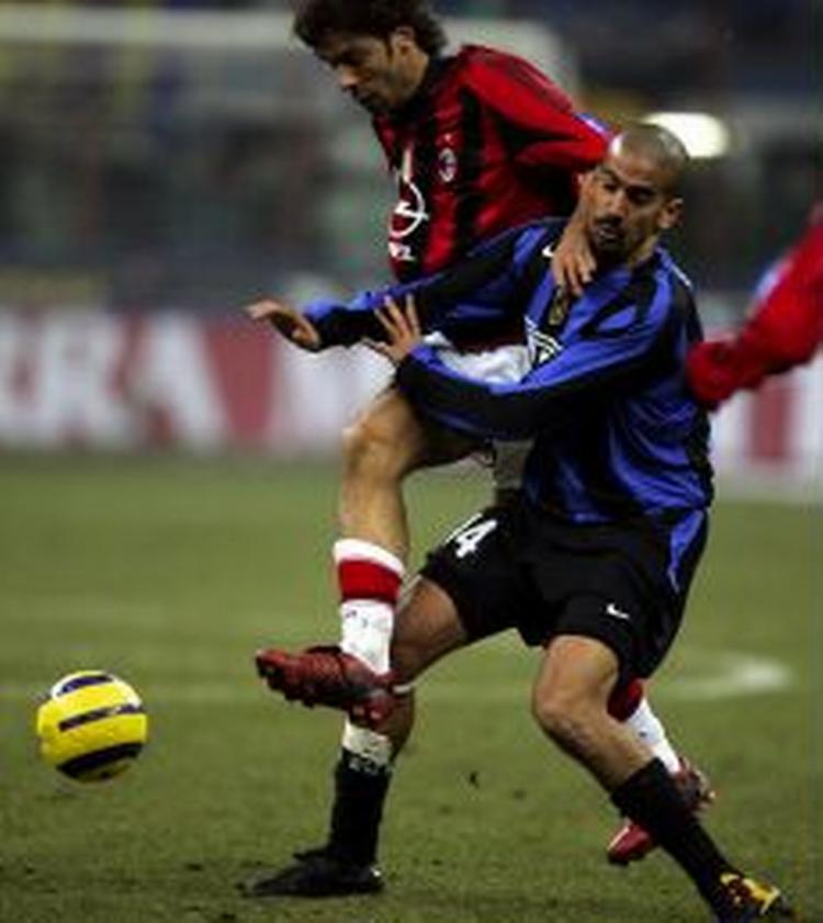Milans portugiser Rui Costa hænger på ryggen af Inters argentiner Veron (blå). - Foto: AP 