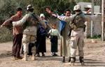 Civile irakere kropsvisiteres under en amerikansk aktion i Ramadi. - Arkivfoto: AP 