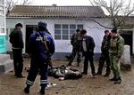 Russiske specialstyrker ved et af ofrene for en aktion i landsbyen Kadyr-Otar i Dagestan for fire dage siden   Foto: Dimitrij Nikiforov/AP 