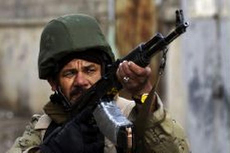 En irakisk soldat er på patrulje i Mosul, men faktisk går det langsomt med at uddanne de irakiske sikkerhedsstyrker. - Foto: AP 
