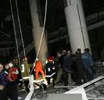 Redningsfolk måtte flygte, da en del af taget i indkøbscentret styrtede sammen. - Foto: AP 