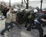 Demonstranter tæver løs på flygtende betjente i Bisjkek. - Foto: AP 