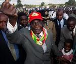 Mugabe triumferer sejrssikkert under et valgkampsmøde. - Arkivfoto: AP 