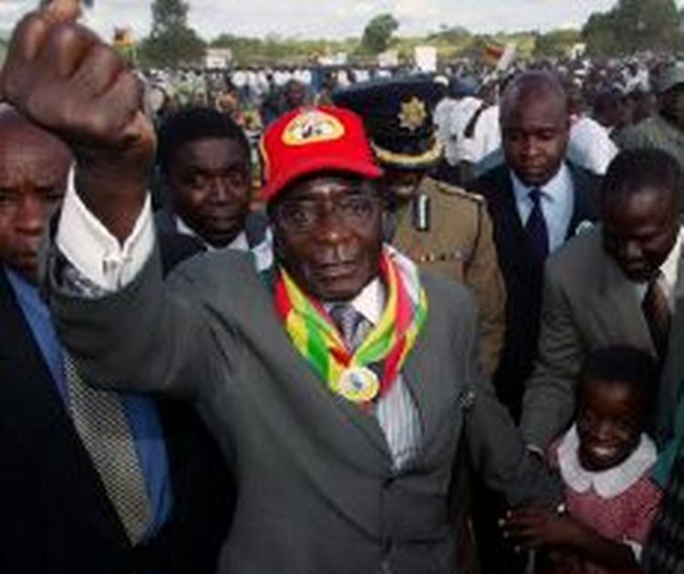 Mugabe triumferer sejrssikkert under et valgkampsmøde. - Arkivfoto: AP 