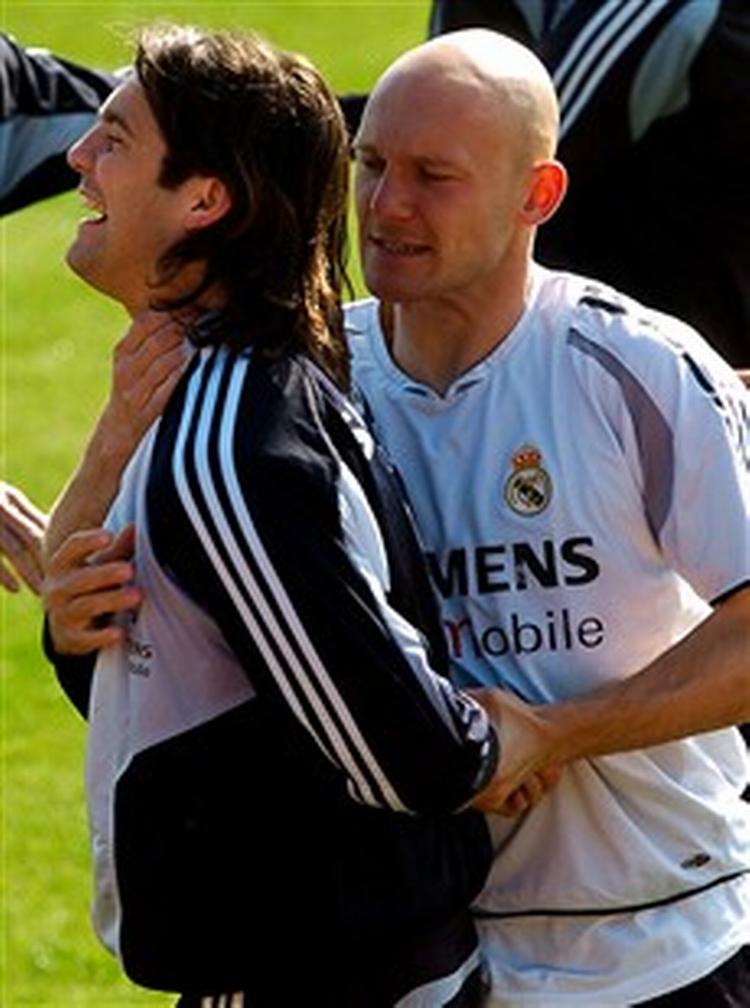 En legesyg Thomas Gravesen viser sin argentinske holdkammerat Santiago Solari, hvor alvorlig situationen er inden søndagens kamp mod Barcelona.   Foto: Juanco Martin/AP 