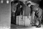 GASMASKER? Af frygt for at tyskerne skulle få fingre i  krigsbogen  fik Bergstrøm (tv) i 1944 Falck til at fragte de 80.000 sider ind til Det Kongelige Bibliotek. Kasserne havde påskriften  gasmasker .   Foto: Tage Christensen 