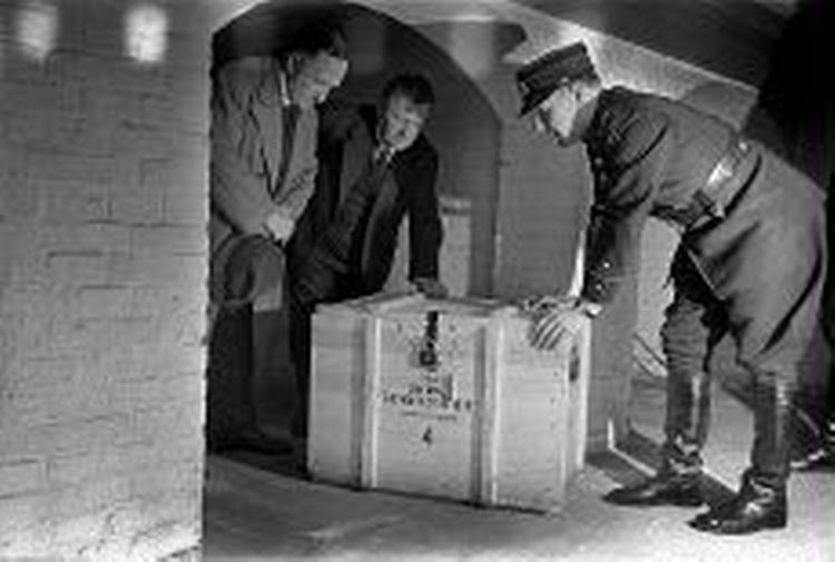 GASMASKER? Af frygt for at tyskerne skulle få fingre i  krigsbogen  fik Bergstrøm (tv) i 1944 Falck til at fragte de 80.000 sider ind til Det Kongelige Bibliotek. Kasserne havde påskriften  gasmasker .   Foto: Tage Christensen 