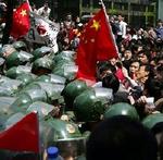 Kinesisk politi holder demonstranter tilbage foran det japanske konsulat i Shanghai. I flere byer trodsede demonstranterne myndighedernes advarsler og gik på gaderne.   Foto: AP 