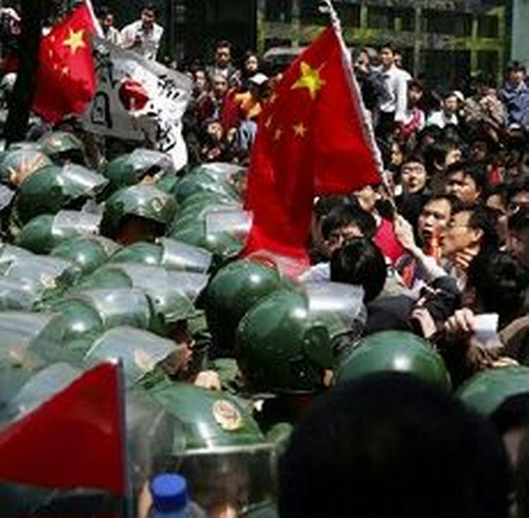 Kinesisk politi holder demonstranter tilbage foran det japanske konsulat i Shanghai. I flere byer trodsede demonstranterne myndighedernes advarsler og gik på gaderne.   Foto: AP 