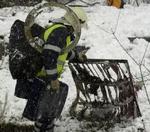 En brandmand samler vragdele sammen efter ulykken. - Foto: AP 