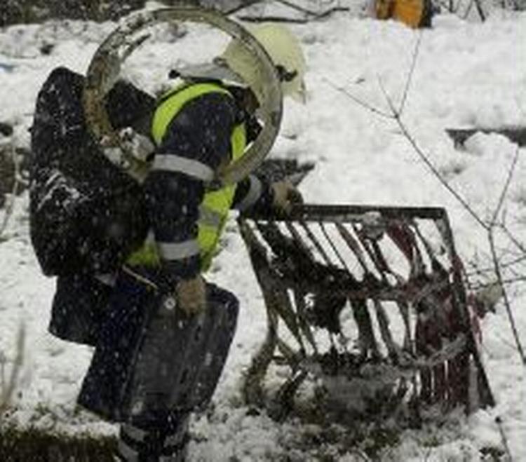 En brandmand samler vragdele sammen efter ulykken. - Foto: AP 