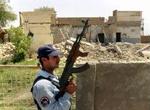 En irakisk politimand bevogter en udbombet moské i Madaen syd for Bagdad. - Foto: AP 