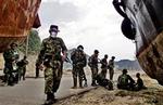 Indonesiske på patrulje holder et øjebliks hvil i kampen mod Acehs oprørere. Ifølge menneskeretsgrupper tager soldaterne også parti, når nødhjælpen skal fordeles.   Foto: Ed Wray, AP 