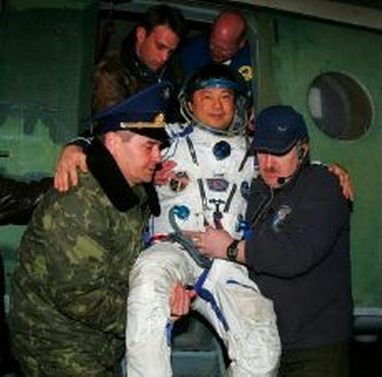 Den amerikanske kosmonaut Leroy Chiao hjælpes ud af rumkapslen af russisk jordpersonale. - Foto: AP 
