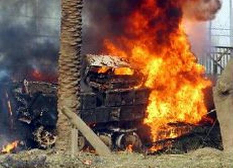 En amerikansk kampvogn brænder i nærheden af Bagdad efter et møde med en irakisk bombe. - Arkivfoto: AP 