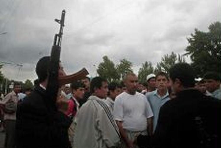 En gruppe bevæbnede oprører taler til indbyggerne i den uzbekiske by Andijan, hvor myndigheder har mistet grebet om byen, efter at op mod 2.000 demonstranter og oprører indtog byen her til morgen. - Foto: AP 