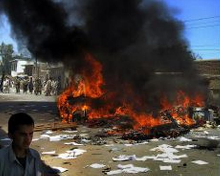 Flere steder i Afghanistan bølger demonstrationerne - her i storbyen Jalalabad, hvor en bil er sat i brand. - Foto: AP 