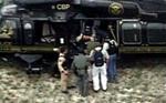 Luis Posada Carriles bliver ført ind i en helikopter af udlændingemyndighederne efter anholdelsen. - Foto: AP 