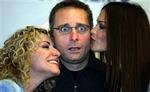 Paolo Bonolis i klemme mellem to kolleger. Den 44-årige quiz-vært tjener kassen på sin 'kunst'. - Foto: AP 