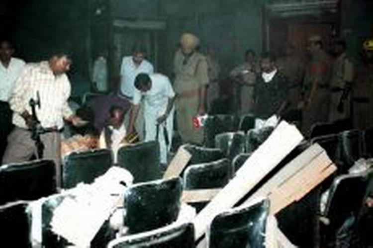 Indisk politi undersøger en biograf i hovedstaden New Delhi, efter at en bombe placeret under et af sæderne sprang og dræbte en og sårede mere end 40. - Foto: AP 