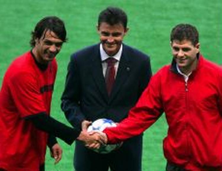 Anførerne mødes. Paolo Maldini (tv.) trykker hånd med Liverpools Steven Gerrard under gårsdagens træning. Manuel Enrique Gonzalez, der skal dømme kampen, sørger for at alt går rigtigt for sig. - Foto: A 
