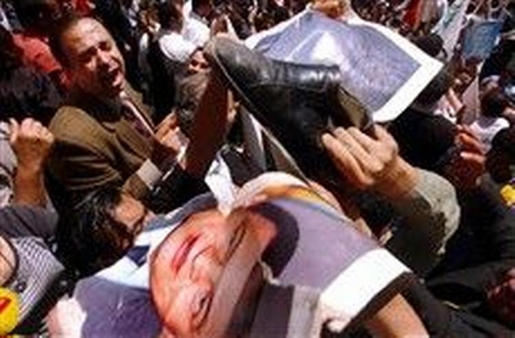 Medlemmer af protestbevægelsen Kifaya (Nok) river billeder af præsident Hosni Mubarak i stykker. - Foto: AP 