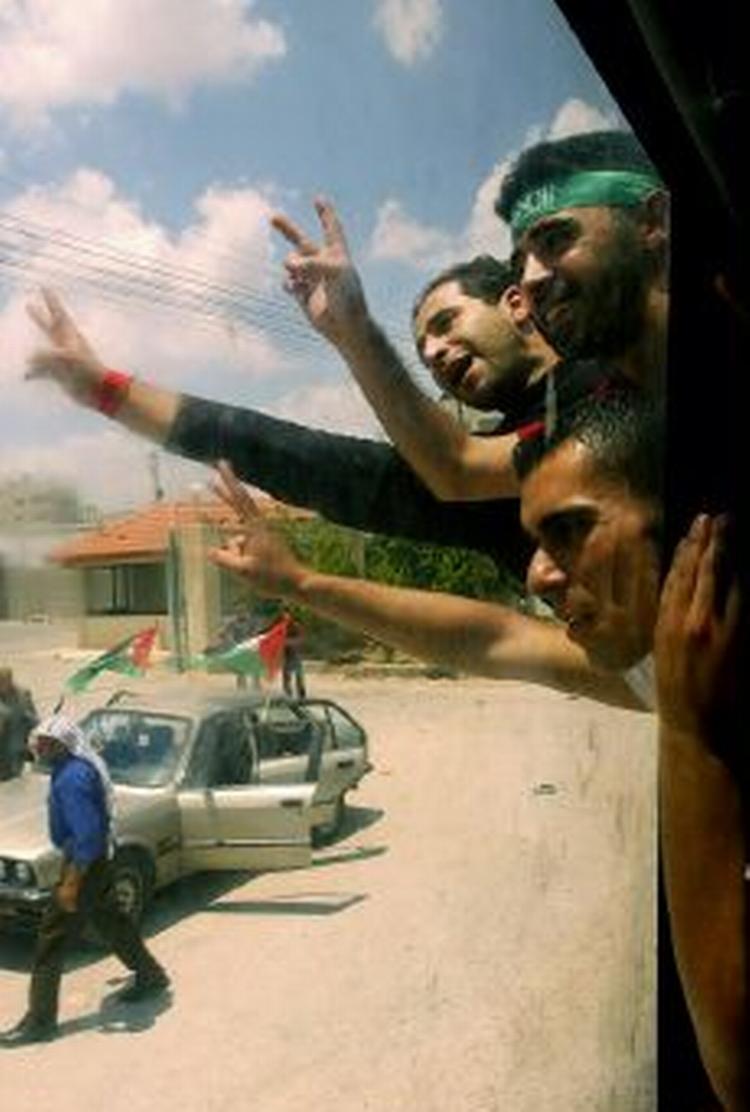 Palæstinensiske fanger viser v-tegnet, ved ankomsten til Nablus i Vestbredden efter deres løsladelse. - Foto: AP 