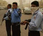 Politifolk bevogter de urolige gader i Bagdad under dagens kraftige sandstorm. - Foto: AP 