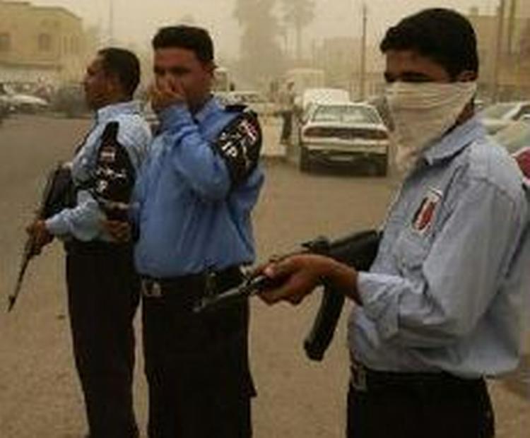 Politifolk bevogter de urolige gader i Bagdad under dagens kraftige sandstorm. - Foto: AP 