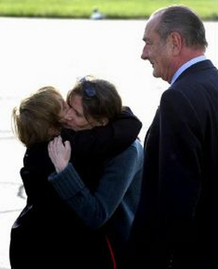 Præsident Chirac ser til, mens Florence Aubenas får et knus af sin mor Jacqueline i lufthavnen. - Foto: AP 