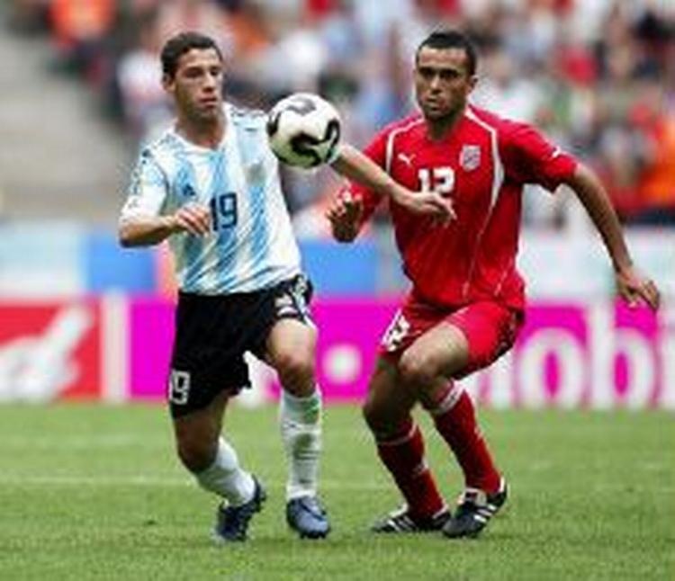 Maximiliano Rodriguez fra Argentina i infight med Tunesiens Jawhar Mnari. - Foto: AP 