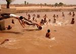 Pakistanske børn får sig en kold dukkert midt i hedebølgen. - Foto: AP 