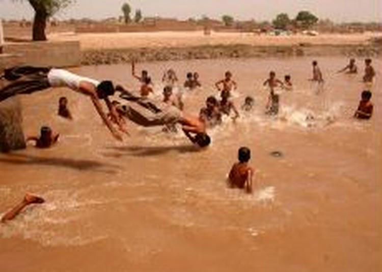 Pakistanske børn får sig en kold dukkert midt i hedebølgen. - Foto: AP 