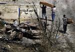 20. juni 2005. En kiste bæres gennem haven på en politistation i Bagdad. Oprørere angreb med tre bil8bomber, mindre håndvåben og raketdrevne granater. Mindst 8 politifolk og en baby blev dræbt.   Foto: AP/Khalid Mohamm 
