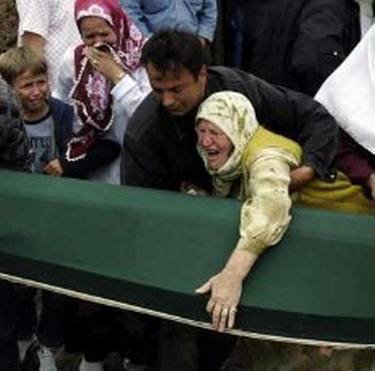 En sørgende kvinde der holder om en af de 610 kister, der blev begravet på tiårsdagen for Srebrenica-massakren. - Foto: AP 
