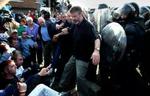 Sinn Fein-leder Gerry Adams kommer i klemme mellem irske nationalister, der protesterer, og politiet. - Foto: AP 