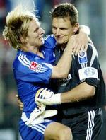 Poulsen i armene på målmand Frank Rost. - Arkivfoto: AP. 