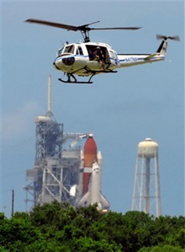En NASA-helikopter fløj astronauterne tilbage fra Discovery-rumfærgen, da afgangen blev udsat på grund af problemer med en måler i en brændstoftank.   Foto: AP 