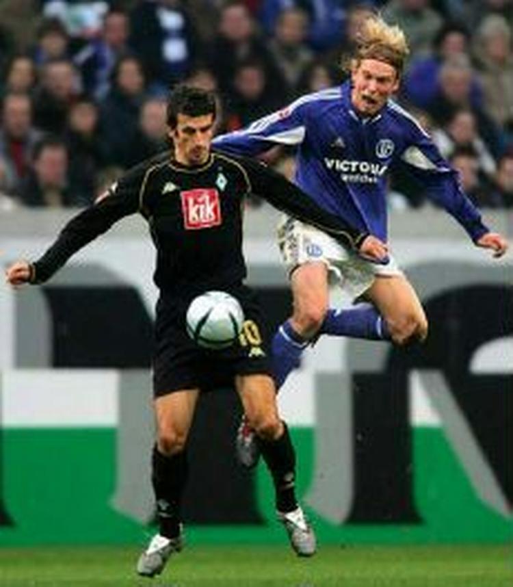 Poulsen i infight med Bremens Micoud. - Arkivfoto: AP. 