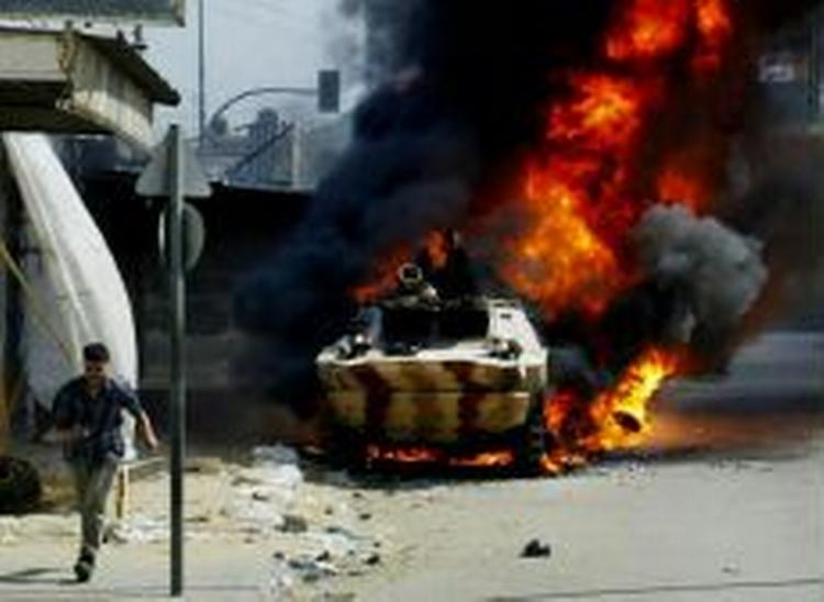 Et palæstinensisk politikøretøj i flammer efter kampe med militante palæstinensere i Gaza By. - Foto: AP 