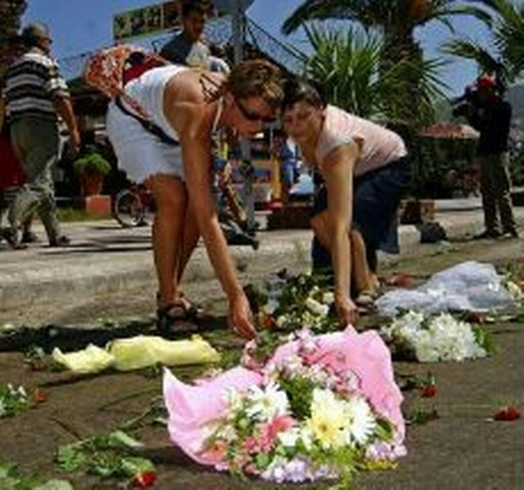 En turist og en tyrkisk kvinde lægger blomster ved gerningsstedet dagen derpå. - Foto: AP 