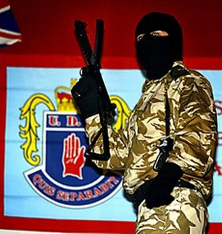 Et bevæbnet medlem af en af de protestantiske paramilitære organisationer, som slås internt.   Arkivfoto: Paul Faith/AP 