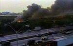 Flere biler stoppede op, da det stod klart, at et passagerfly var brudt i brand. - Foto: AP 